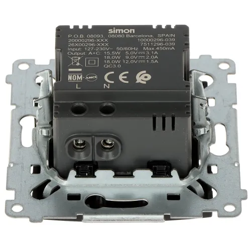 Zdjęcie przedstawia metalowy mechanizm gniazdka elektrycznego marki Simon, z widocznymi oznaczeniami technicznymi i certyfikatami na czarnym tle. Elementy montażowe są wykonane z metalu, a całość jest przygotowana do instalacji w ścianie.