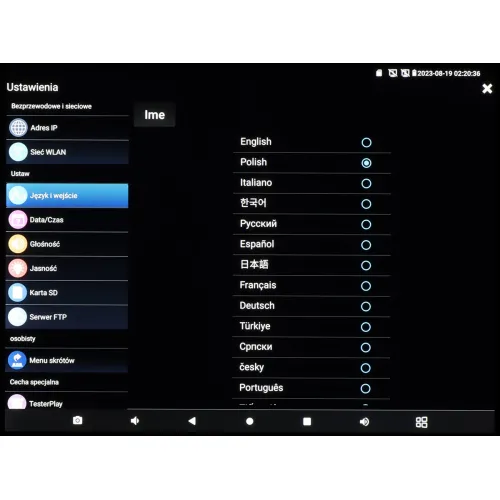 Ekran ustawień urządzenia elektronicznego z wyświetlonym menu wyboru języka, zawierającym opcje takie jak English, Polish, Italiano i inne. Po lewej stronie widoczne są dodatkowe opcje menu, takie jak Adres IP, Sieć WLAN i Język i wejście.