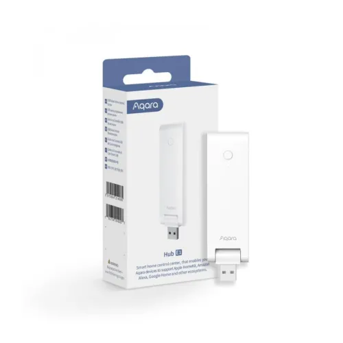 Na zdjęciu znajduje się biały hub Aqara E1 w formie urządzenia USB, obok którego stoi jego opakowanie. Opakowanie jest również białe z niebieskimi akcentami i zawiera logo Aqara oraz opis produktu.