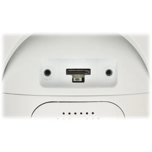 Zdjęcie przedstawia gniazdo karty pamięci oraz przycisk reset na białej powierzchni urządzenia. Widać również dwa otwory montażowe po bokach gniazda.