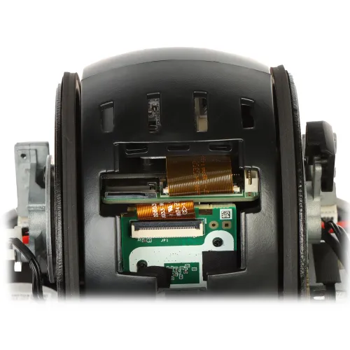 Zdjęcie przedstawia wnętrze kamery po zdjęciu klosza, ukazując szczegóły elektroniki i okablowania. Widoczne są elementy takie jak płytka drukowana i taśmy przewodzące.