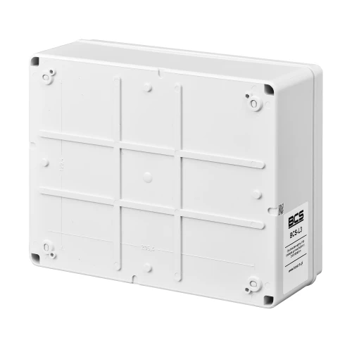 Biała, prostokątna obudowa zewnętrzna z tworzywa sztucznego, posiadająca kilka otworów montażowych na krawędziach. Na powierzchni widoczne są delikatne linie strukturalne oraz logo BCS w dolnym rogu.