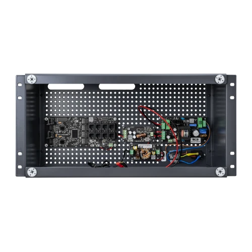 Na zdjęciu znajduje się switch PoE BCS UPS-IP16-E-S-R zamontowany w metalowej obudowie z perforowanym panelem tylnym. Wewnątrz widoczne są różne komponenty elektroniczne oraz okablowanie.