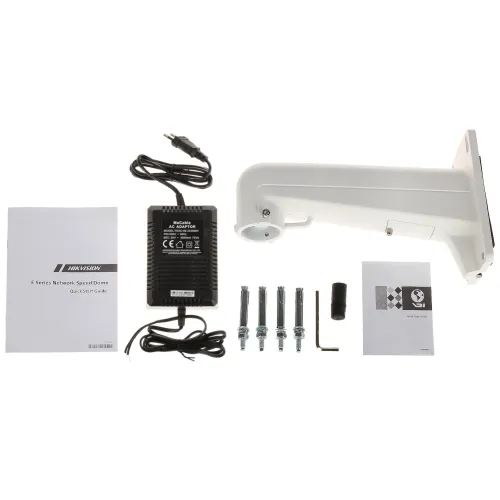 Na zdjęciu znajduje się zestaw montażowy do kamery, w skład którego wchodzą uchwyt, zasilacz, śruby montażowe, klucz imbusowy oraz instrukcje obsługi. Elementy są rozłożone na białym tle, co ułatwia ich identyfikację.