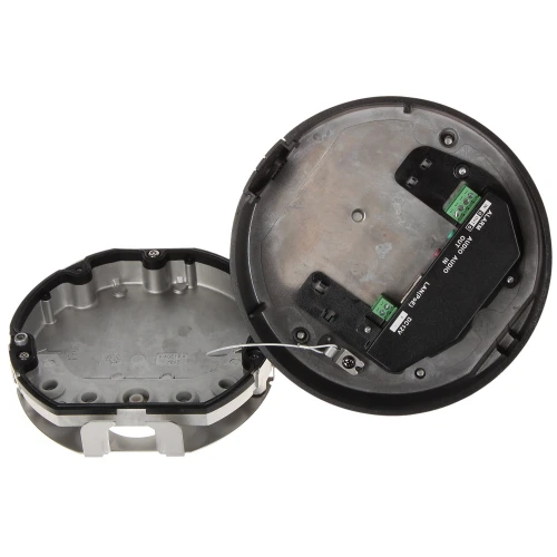 Zdjęcie przedstawia otwarty, okrągły czujnik z metalową obudową i widocznymi złączami elektrycznymi. Wnętrze urządzenia pokazuje szczegóły montażowe i okablowanie.