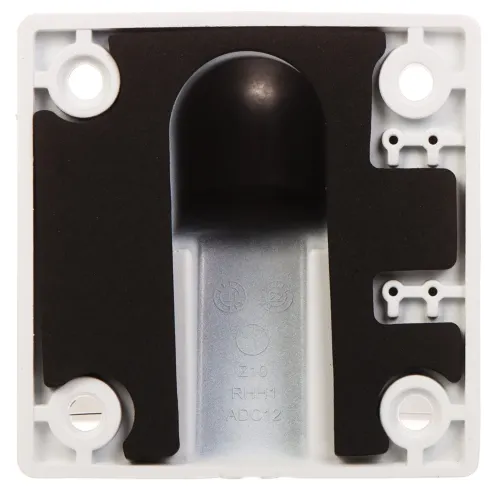 Zdjęcie przedstawia wnętrze plastikowej obudowy z czterema otworami montażowymi w rogach i centralnie umieszczonym elementem z czarnego materiału. Wewnątrz widoczne są oznaczenia techniczne oraz struktura umożliwiająca montaż dodatkowych komponentów.