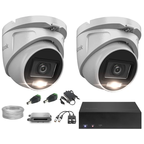 Na zdjęciu znajduje się zestaw do monitoringu, który obejmuje dwie kamery kopułkowe, rejestrator, przewody oraz zasilacze. Kamery mają nowoczesny design i są wyposażone w oświetlenie LED.