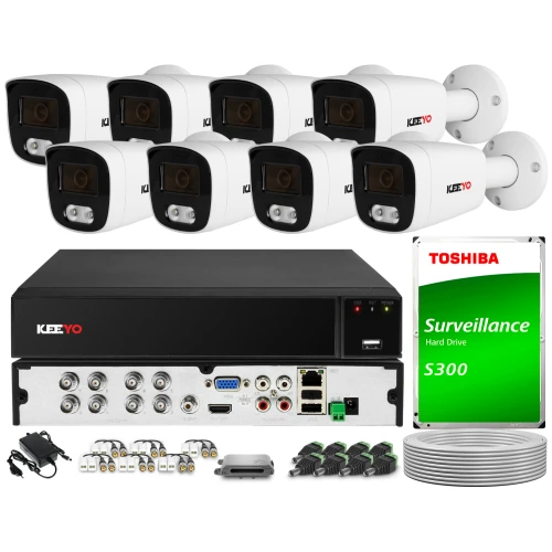 Zestaw do monitoringu składający się z ośmiu kamer, rejestratora, dysku twardego Toshiba oraz niezbędnych akcesoriów i kabli. Kamery są białe z czarnymi elementami, a rejestrator posiada różnorodne porty do podłączenia.